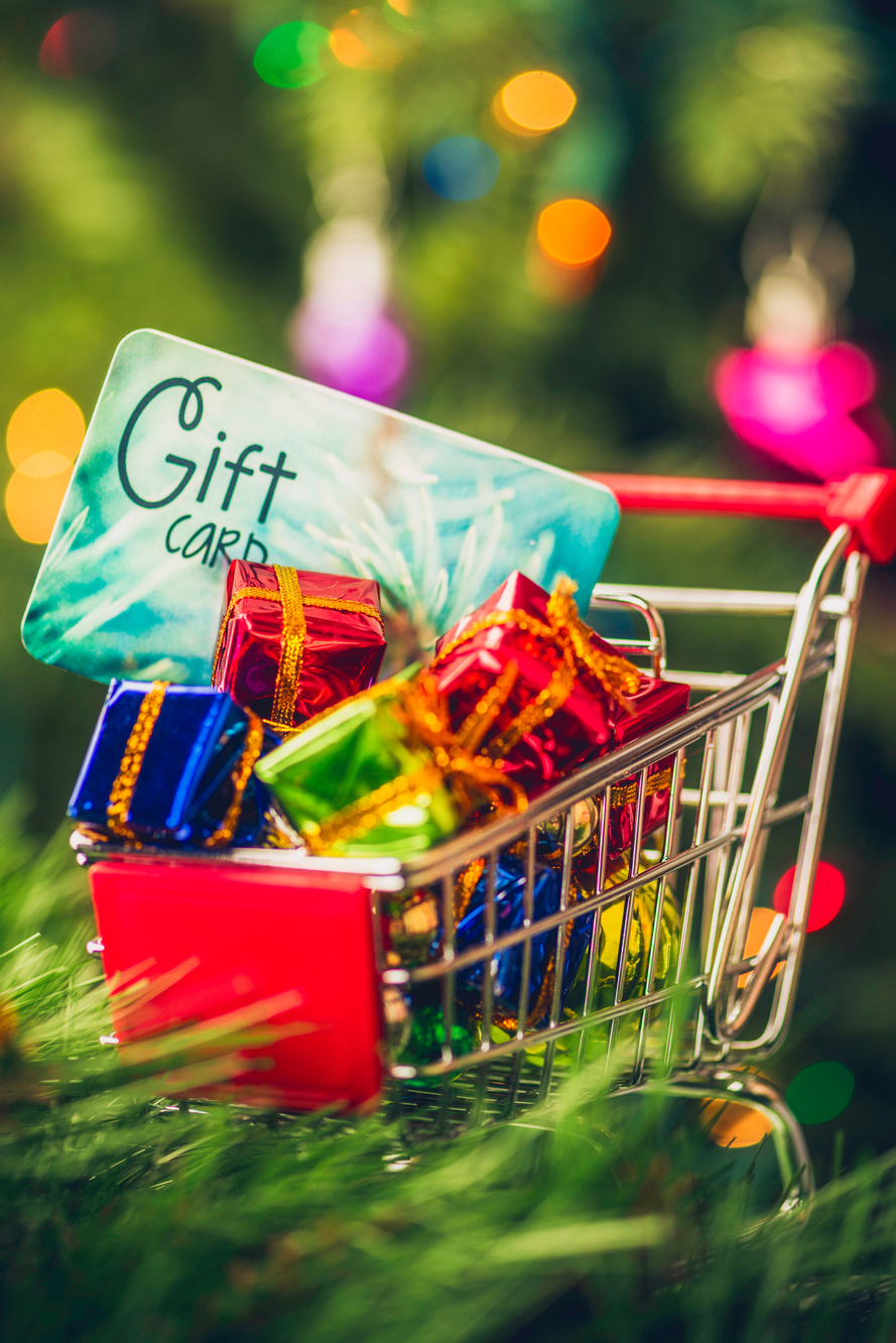 Christmas gift card in shopping cart with gifts